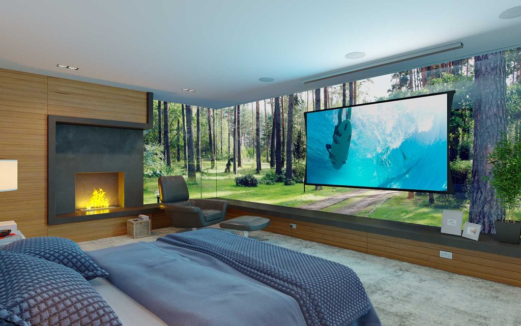 A modern bedroom with a fireplace, gray bed, and large windows showing a forest view. A big TV screen displays an underwater scene, creating a cozy and immersive atmosphere.